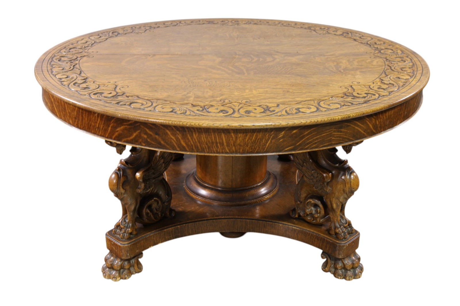 RJ HORNER AM. OAK DINING TABLE: LARGE AMERICAN OAK WINGED GRIFFIN DINING TABLE BY RJ HORNER, FULL FORM WINGED GRIFFIN BASE, SPLIT PEDESTAL, MINOR WEAR TO FINISH AND VENEER CHIPS, WITH CARVED TOP/SKIRTED LEAVES & 9 UN SKIRTED LEAVES