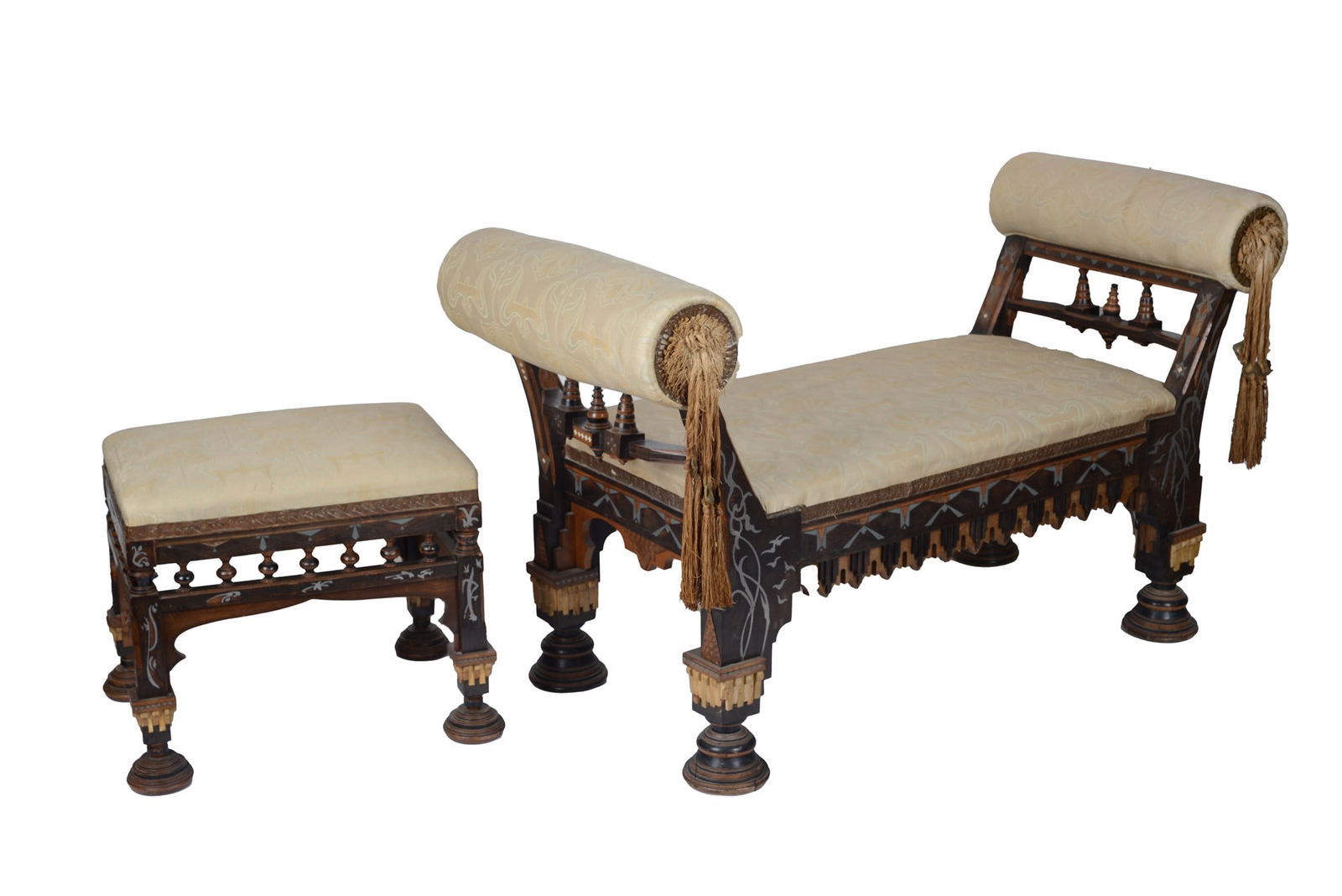 Carlo Bugatti (Milano, 1856 - Molsheim, 1940) - Un divanetto con pouf: In stile orientalista, struttura in legno scolpito e intarsiato con motivi geometrici e vegetali, poggiante su piedi torniti e modanati, braccioli laterali a rullo con nappe pendenti, seduta e schiena