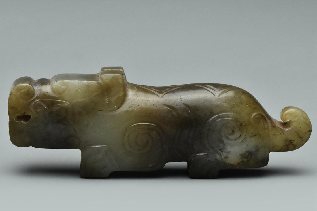 A HAN DYNASTY JADE FIGURE OF A MYTHICAL BEAST: A WESTERN HAN DYNASTY JADE FIGURE OF A MYTHICAL BEAST. Dimensions: 3 x 1 x 1/2 in. High resolution pictures can be found at https://file.ac/21euCO1oZvBo6IJly2J5IA/