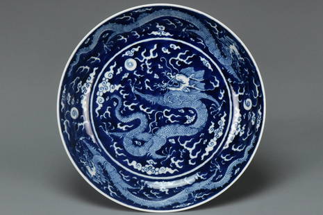 A LARGE DRAGON DISH QIANLONG MARK AND PERIOD: A LARGE BLUE AND WHITE DRAGON DISH QIANLONG MARK AND PERIOD. Dimensions: 10 1/4 x 2 in. Provenance: From the collection of Charles George(1898-1983). Manager of Sir Victor Sassoon's Empire in China, M