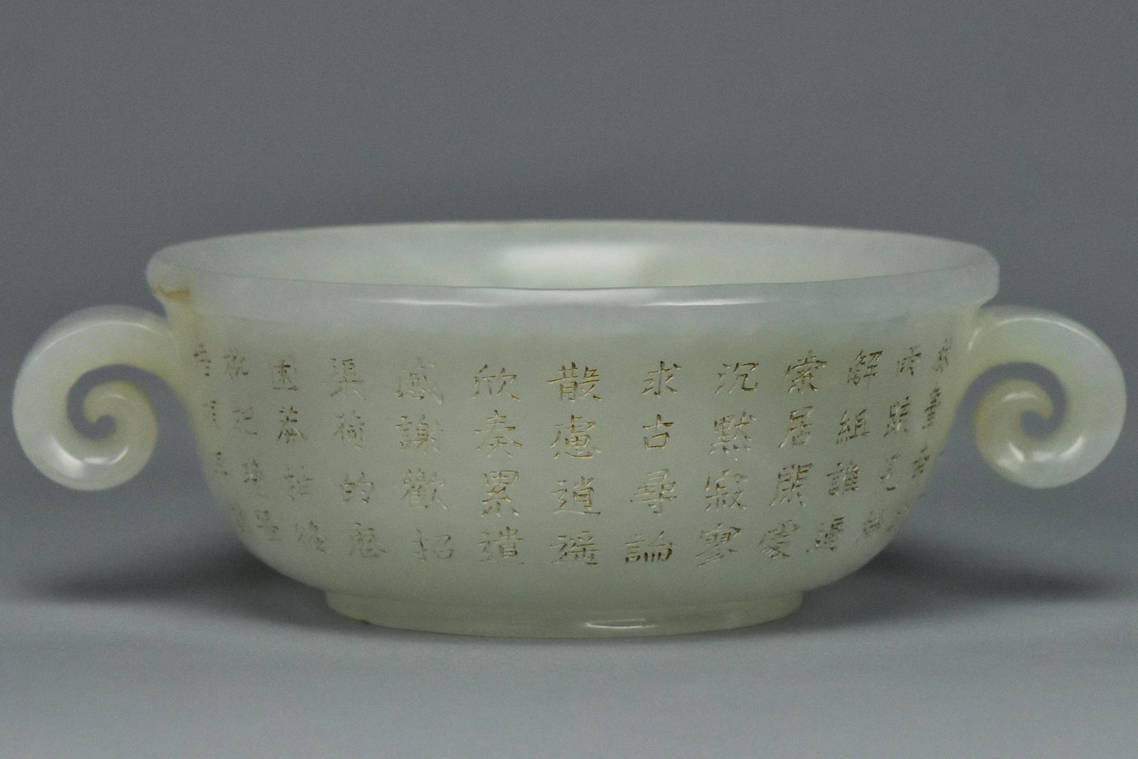 INSCRIBED WHITE JADE CUP QIANLONG MARK AND PERIOD: AN INSCRIBED WHITE JADE WINE CUP QIANLONG MARK AND PERIOD. Dimensions: 4 3/4 x 3 1/2 x 1 1/2 in. Provenance: From the collection of Charles George(1898-1983). Manager of Sir Victor Sassoon's Empire in