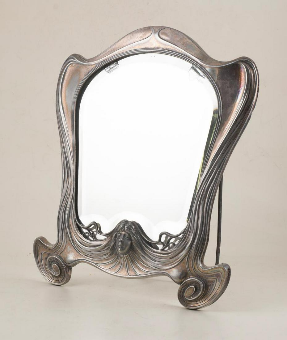 Silvered metal table-top mirror. Art Nouveau. Circa: Silvered metal table-top mirror. Art Nouveau. Circa 1900. Marked Orivit and numbered 2280. There are two imperfections inside the mirror. 37 x 29,5 cm.