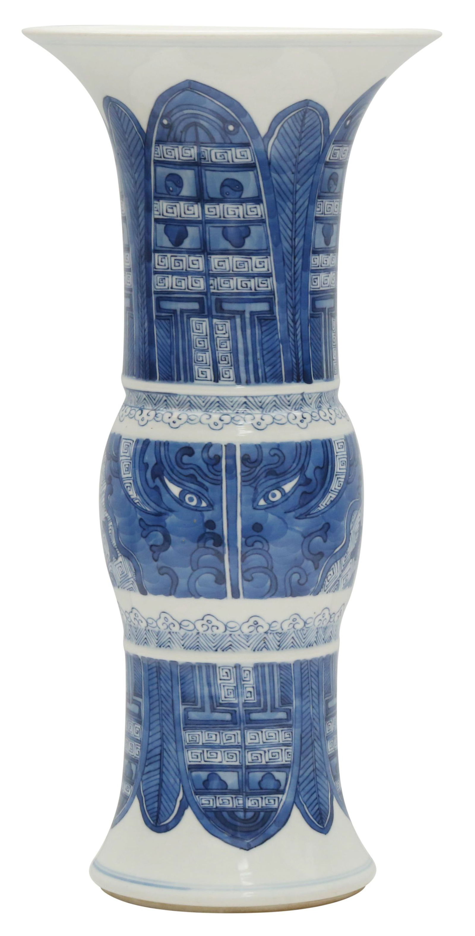 A CHINESE BLUE AND WHITE 'ARCHAISTIC' BEAKER VASE, GU: A CHINESE BLUE AND WHITE 'ARCHAISTIC' BEAKER VASE, GU Qing Dynasty, Kangxi Period. The curved central section painted to either side with an archaistic taotie mask design enclosed between rows of ruyi