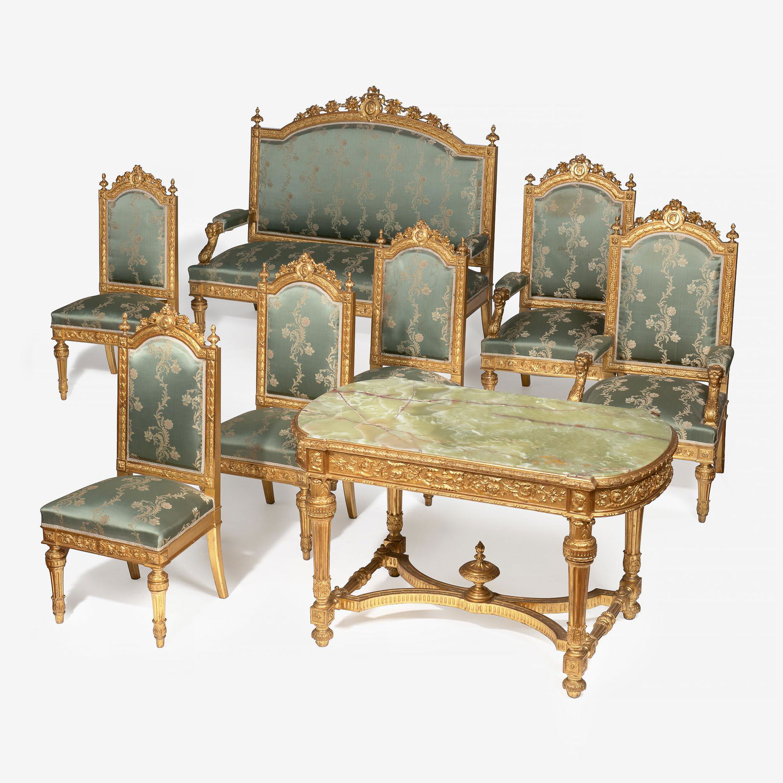 A Napoleon III eight-piece salon suite: Third quarter 19th century Comprising a giltwood bench, matching center table with shaped green onyx top, two matching armchairs and six side chairs, each with carved medaillon with profile bust, surr