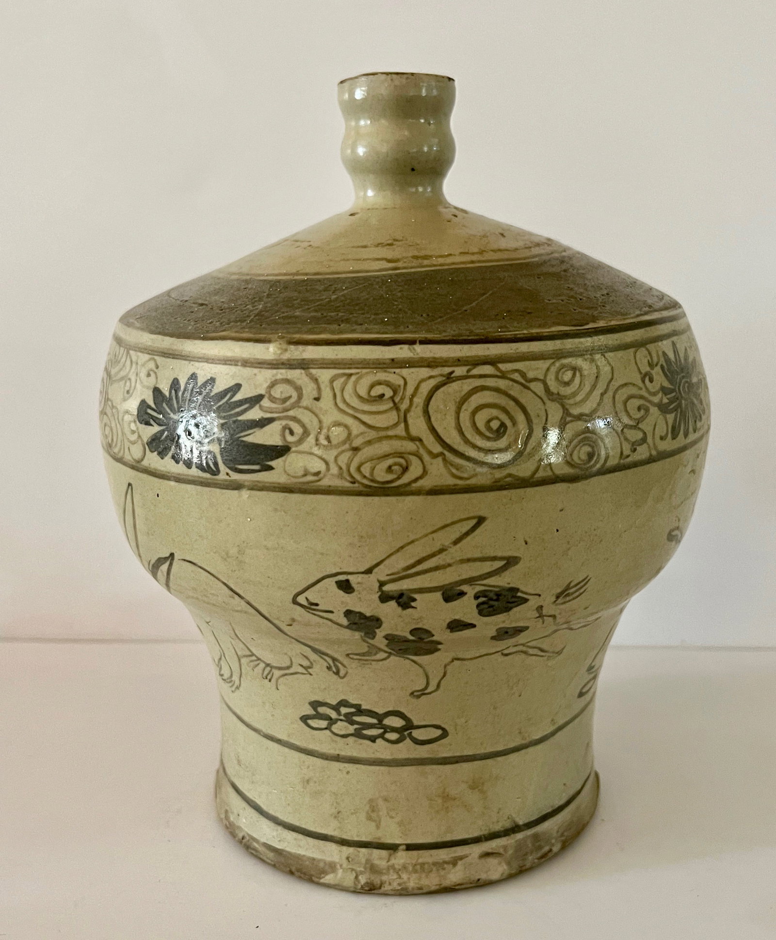 Early Edo Period Rabbit Sake Bottle: This Japanese Edo Period (1603-1868) Sake Bottle is decorated with multiple underglaze rabbits at play. First half 18th century. 8.5 inches tall.