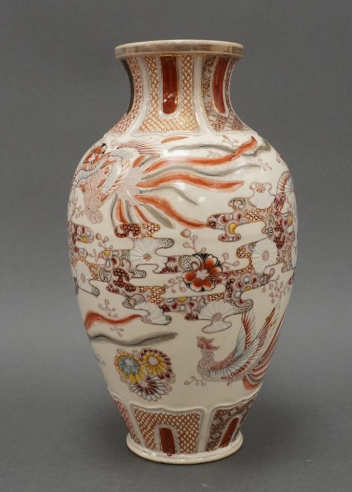Vintage Large Japanese Earthenware Vase: This impressive mid-20th century Japanese earthenware vase is richly decorated with phoenix and floral motifs rendered in raised enamels. The phoenix, a traditional symbol of renewal, virtue, and pros