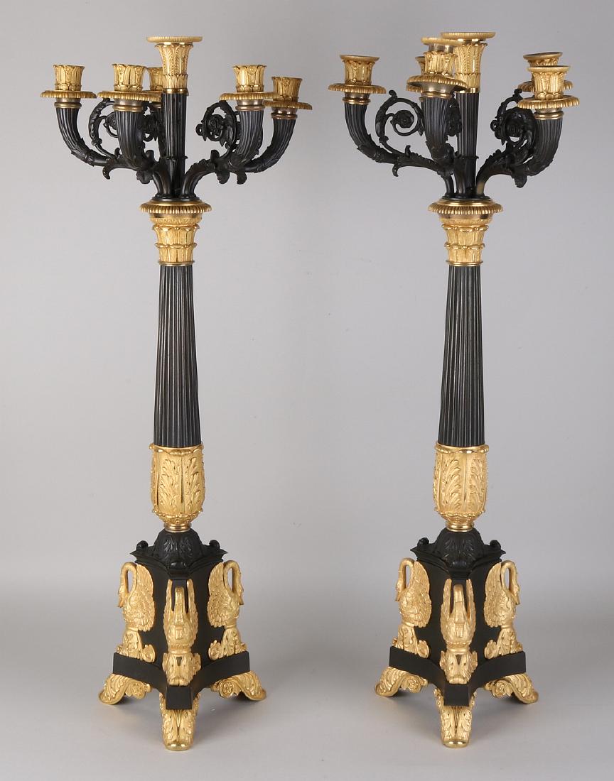 Two capital large fire-gilt Empire candle holders with: Two capital large fire-gilt Empire candle holders with swans. Circa 1820. Dimensions: 74 x 26 x 26 cm. In good condition.