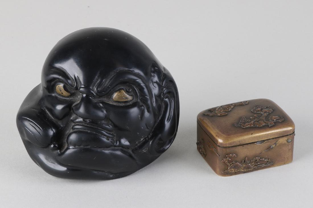 Twice old Japanese antiques. Consisting of: Japanese: Twice old Japanese antiques. Consisting of: Japanese natural stone paperweight in face shape, circa 1900. And a Japanese brass snuff box with fine figure designs around, 19th century. Dimensions: 9 x