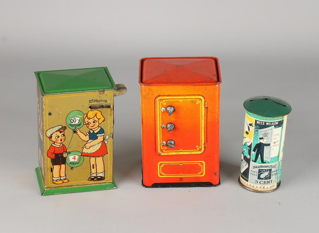 Three old German tin piggy banks. Comprising: Austrian: Three old German tin piggy banks. Comprising: Austrian postal savings bank, made in Germany, circa 1920, and safe model, Western Germany. Circa 1950. Size: 10-13 cm. In good condition.