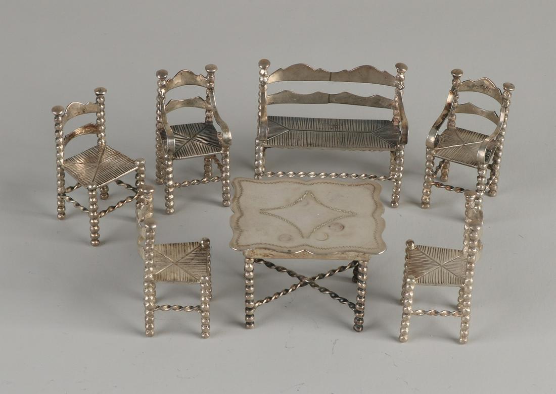Lot with 7 silver miniatures, 835/000, with 5 button: Lot with 7 silver miniatures, 835/000, with 5 button chairs of which 2 with backrest, a bench and a rectangular contoured table. MT.:J. Posthmus, Amsterdam. 1905-1955. 2.5x2.5x4.5cm, 5x
