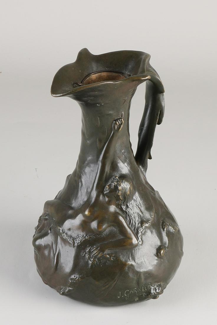 Antique signed bronze Jugendstil jug. Circa 1900.: Antique signed bronze Jugendstil jug. Circa 1900. By J. Garnier. 1853 - 1910. Nude woman in landscape decor. Dimensions: H 21 cm. In good condition.