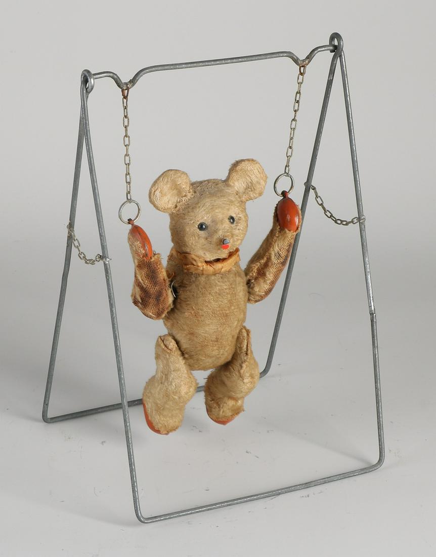Antique tin mechanical toy bear with mohair on swing.: Antique tin mechanical toy bear with mohair on swing. Circa 1920. Schuco? Played. Size: 22 x 16 x 12 cm. In good condition.