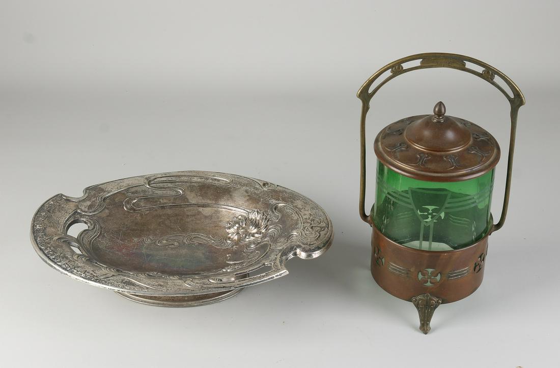 Two parts Jugendstil, 1900: Two parts antique Jugendstil. Circa 1900. (1) Brass cookie jar with glass holder. (2) Nickel-plated bowl with a woman's head/water lily decor. Dimensions: 27 - 30 cm. In good condition.