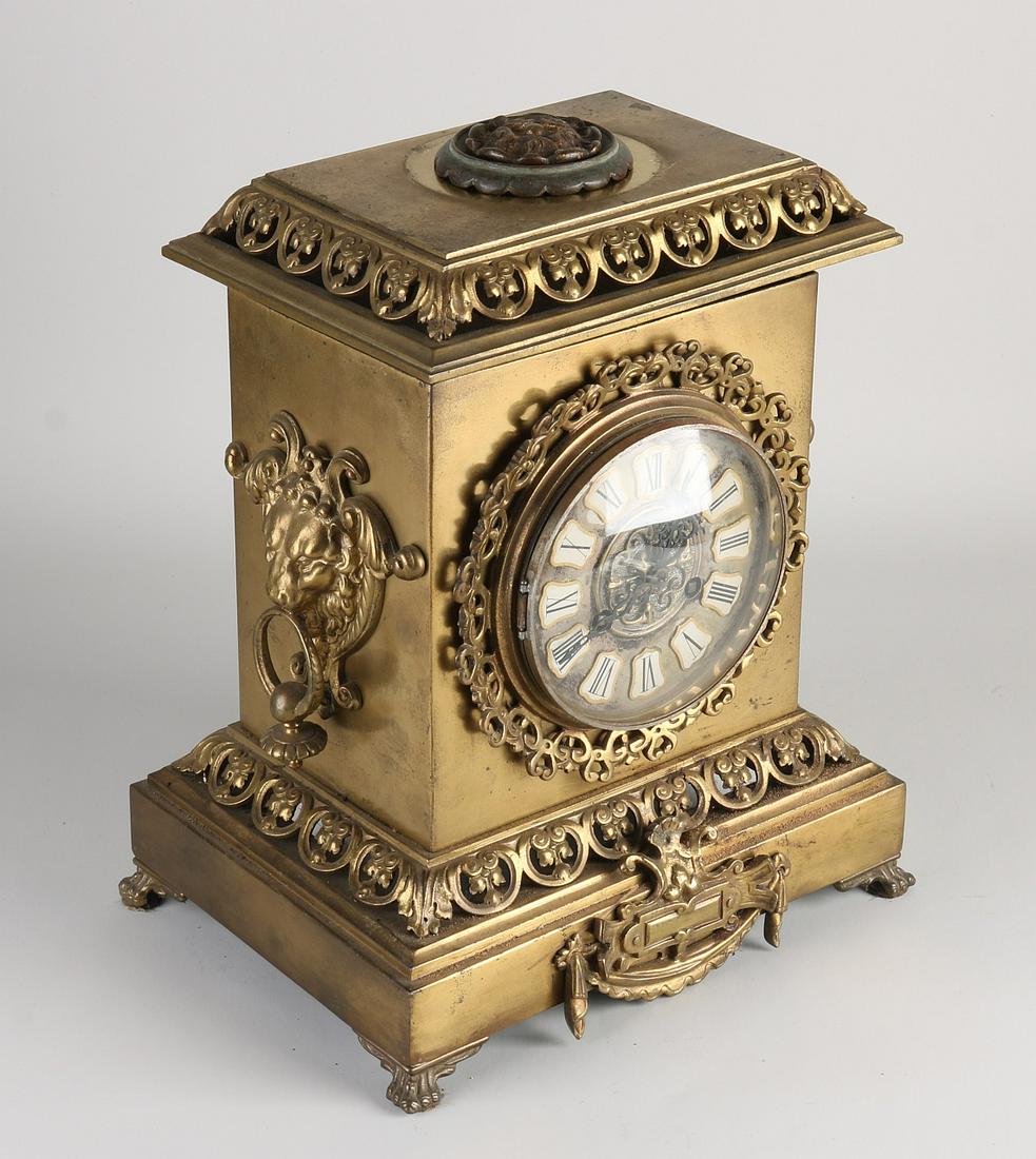 Antique French mantel clock, 1900: Antique French brass mantel clock with lion heads. Circa 1900. Eight-day movement, half-hourly strike on bell. Dimensions: 32 x 26 x 18 cm. In good condition.