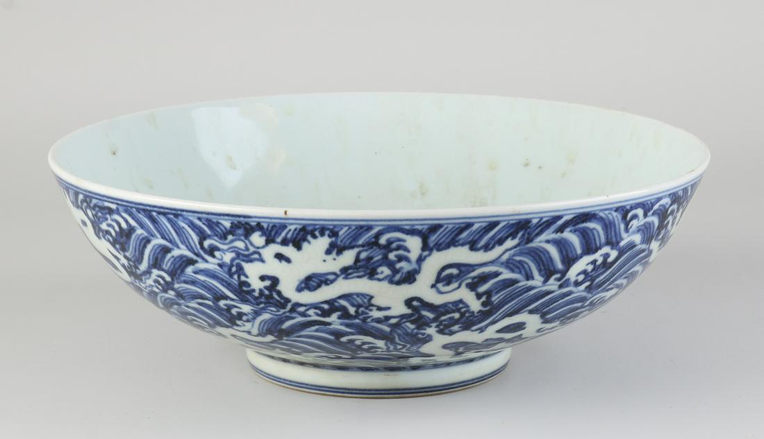 Large Chinese bowl Ã˜ 26 cm.: Large Chinese porcelain bowl with dragons in a cloud decor. With six characters bottom mark. Dimensions: H 8.5 cm. x 26 cm. In good condition.