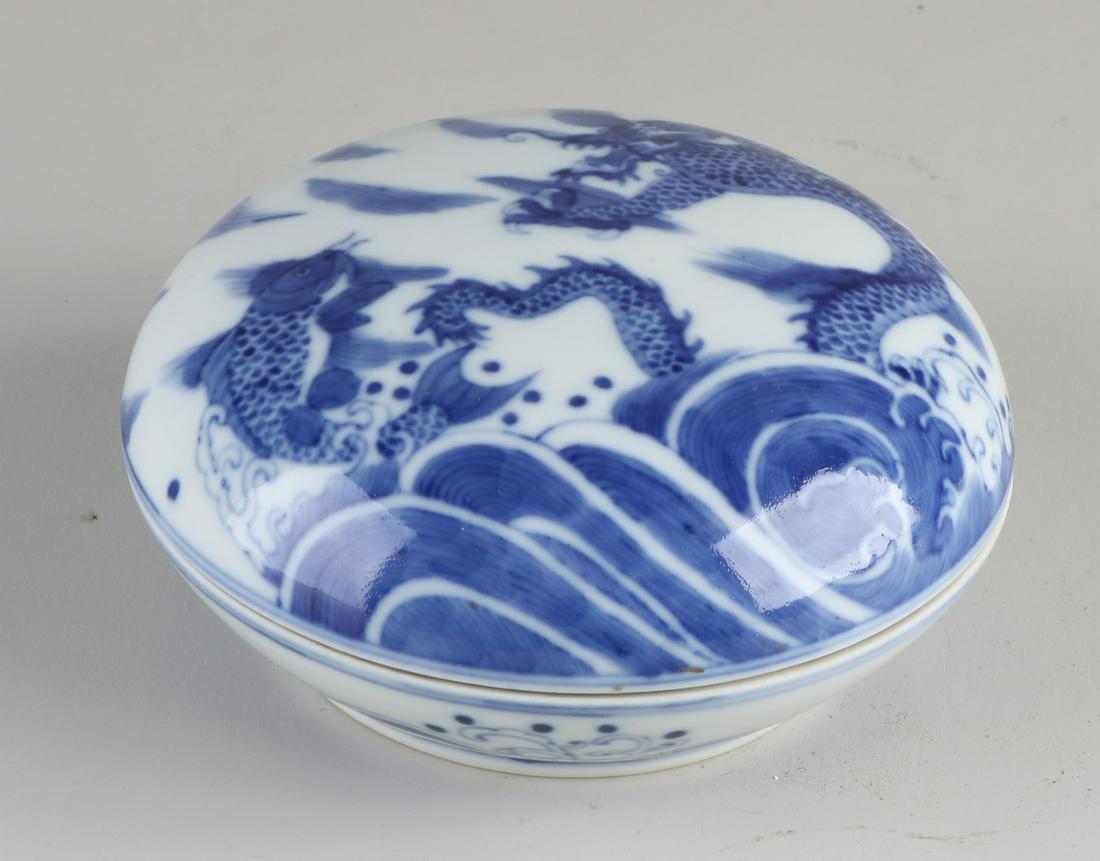 Chinese lidded box, Ã˜ 12 cm.: Chinese porcelain lidded box with dragon/carp decor + six characters bottom mark. Dimensions: H 6 x Ã˜ 12 cm. In good condition.