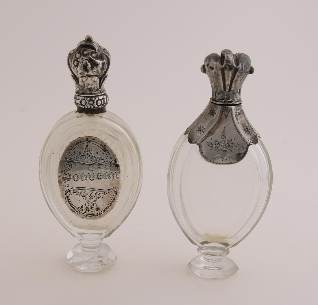 2 Odeur flasks with silver: Two crystal odeur flasks with silver, 835/000. A bottle of oval shape placed on a base and fitted with a large collar with engraving and a contoured silver cap. And an oval model placed on a crystal b