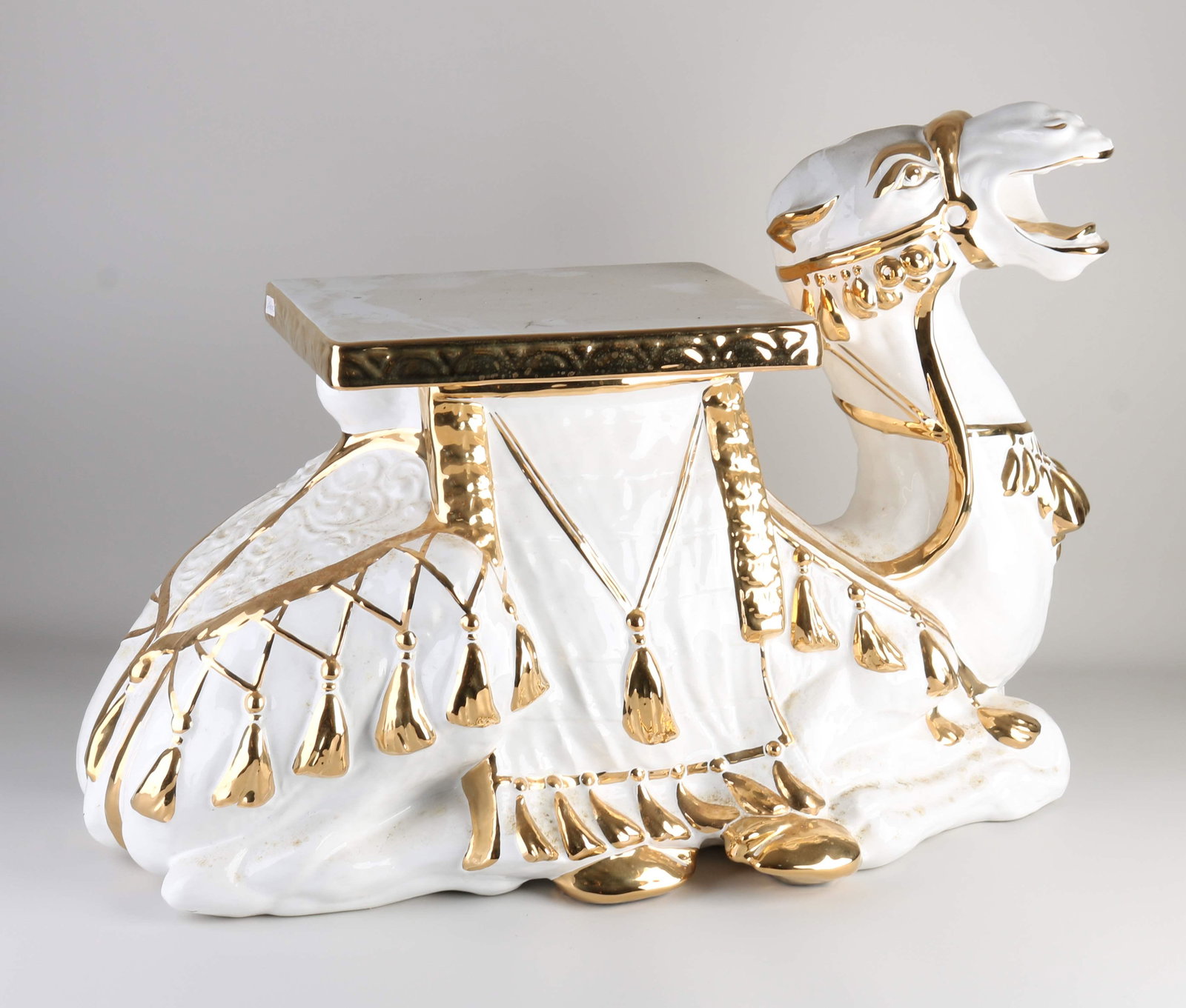 Ceramic hocker, Reclining camel: Large Italian 90s-style ceramic hocker with gold decor. Lying camel. Dimensions: 49 x 67 x 45 cm. In good condition.