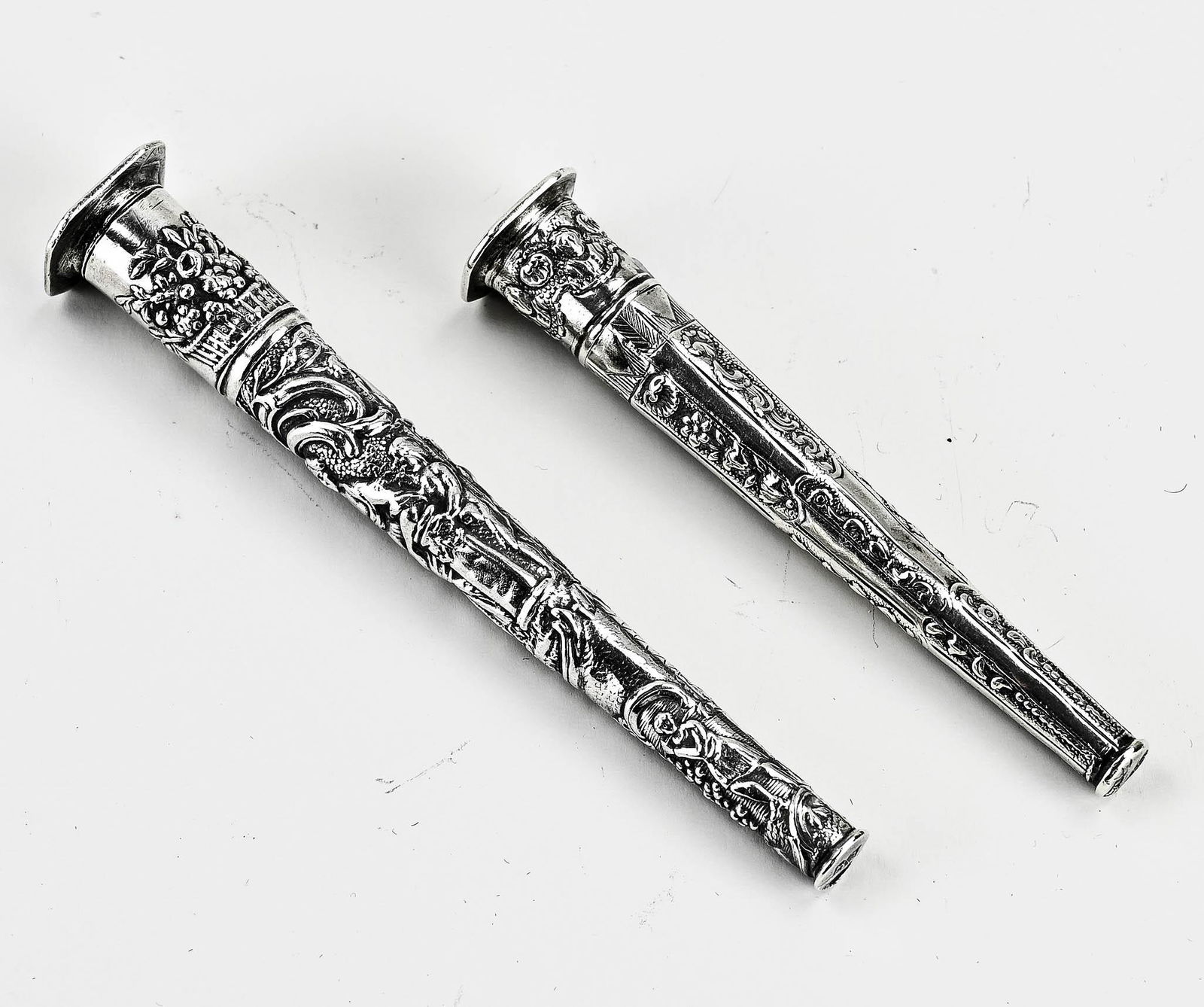 Two 18th century silver needle cases: Two 18th century silver needle cases, one with decorated pieces with floral decor, size: Isaak Schenk, Amsterdam, 1772-1794, dent in, 8.5 cm., and a case decorated with figures and floral decor. MT.: