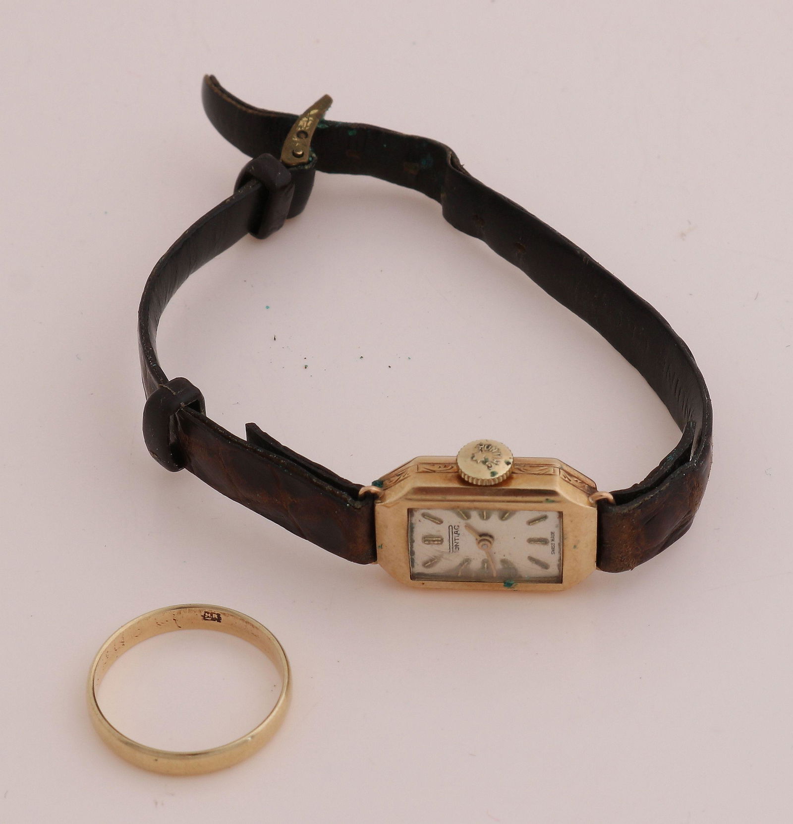 Gold ring and watch: Yellow gold ring and watch, 585/000. Yellow gold wedding ring, width 3 mm, Ã¸ 53, and a watch with yellow gold rectangular contoured case and leather strap. Pontiac, mechanical, working.