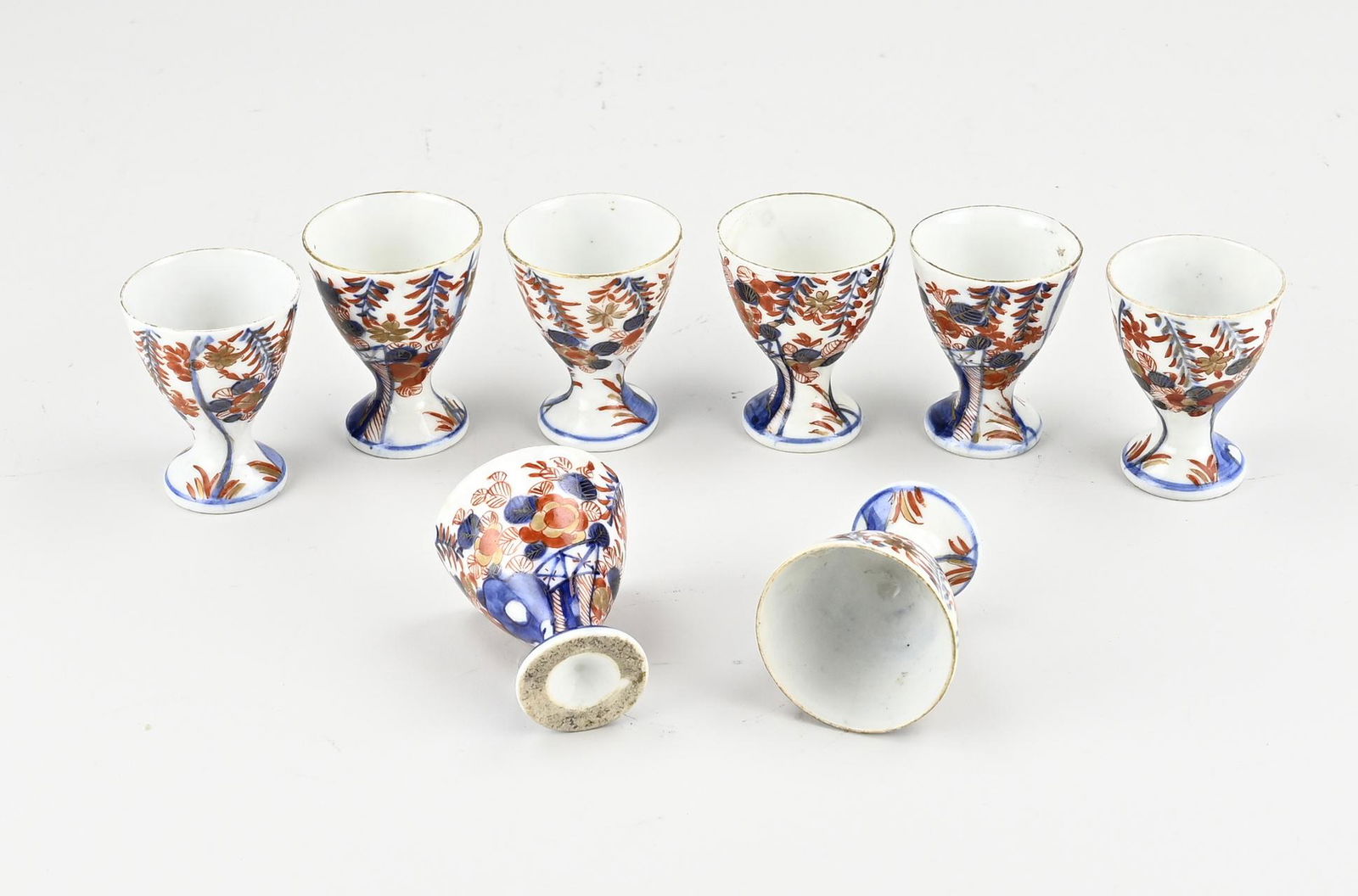 Eight rare Japanese Imari egg cups: Eight rare Japanese Imari porcelain egg cups with garden/gold decor. 19th century. Size: H 6 cm. In good condition.