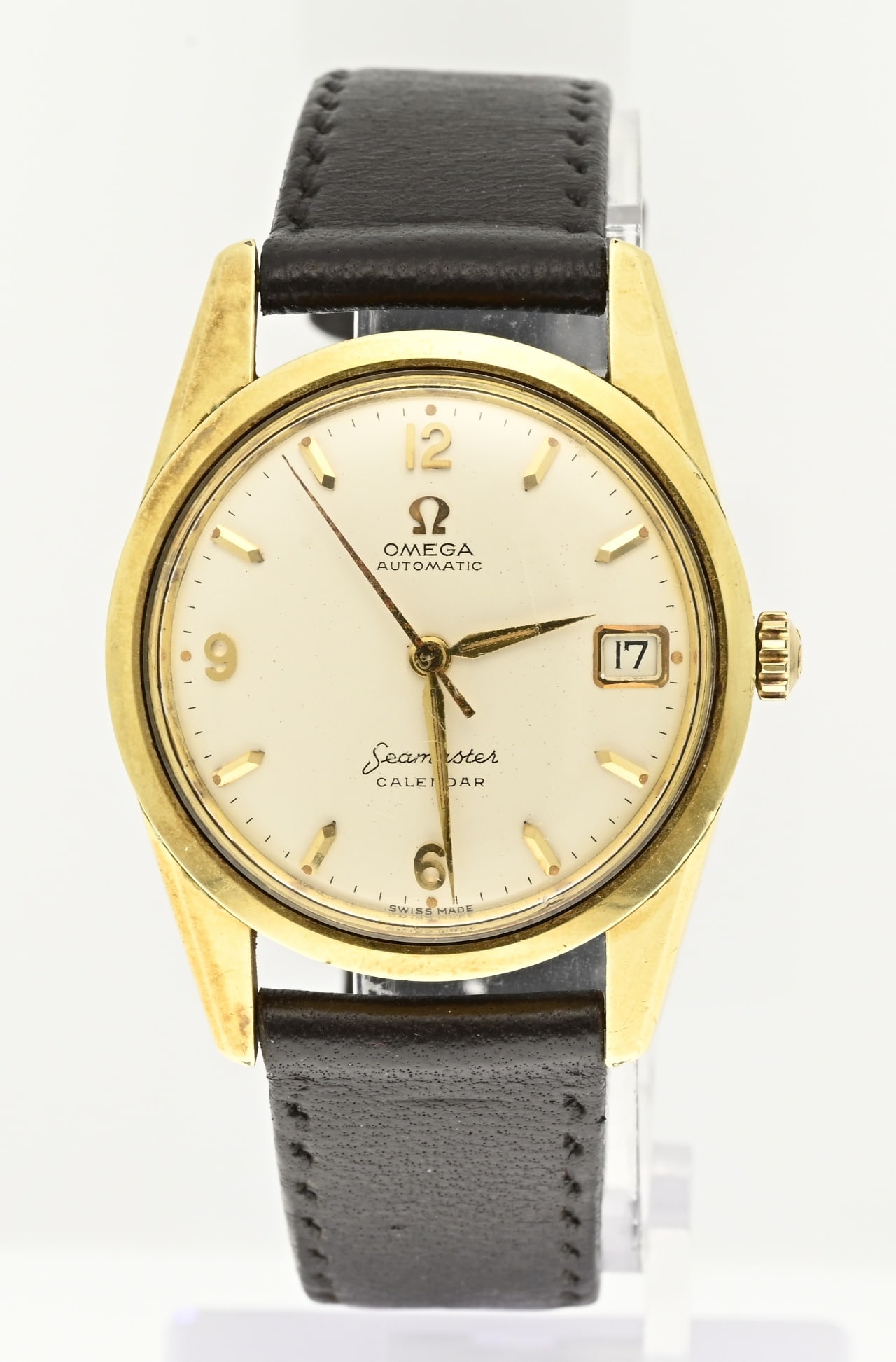 Watch Omega Seamaster: Watch Omega Seamaster, automatic, calendar, gold on steel, with a cream-colored dial with date display. ø 34 mm. The second hand has some rust. With brown leather strap. In good condition. Working