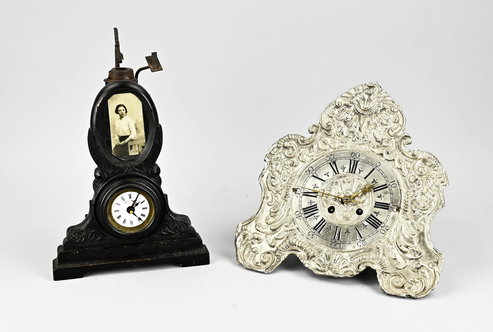 Two antique clocks: Two antique clocks. 1x Separate travel alarm clock with burner? (worm birth). 1x German wall clock (wedding), defective. Size: 30 - 31 cm. In decent shape.