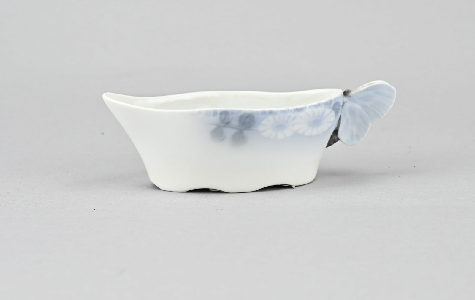 Royal Copenhagen milk jug: Royal Copenhagen porcelain milk jug. Design by Arnold Krog 1856 - 1931. Decor: Midsummers night dream. One chip butterfly. Dimensions: 13 x 5.5 x 4 cm. In decent shape.