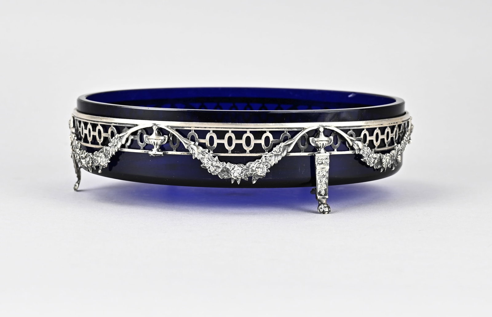 Silver jardiniere/blue glass: Silver jardinaire, 833/000, with blue glass. Oval openwork jardinaire placed on claw feet, 2 are missing, with floral decor and vases, garlands. Total approx. 559 grams. 20x14x6cm. Some restoration sp