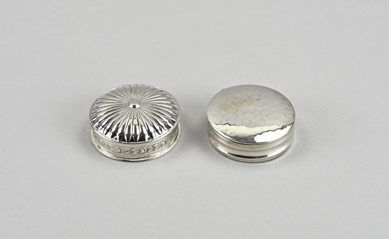 2 Silver pill boxes: Two silver pill boxes, 835/000, round model, one with hammer strike, broken hinge, ø 4 cm. And a box, ø 4.3cm. with a decorated edge and a lid with decor. approx. 41 grams. In good condition.