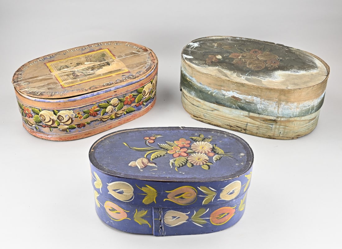 3x Antique hat box: Three antique chipboard hat boxes. 1x Blue with floral painting. 1x Light blue with worn painting. 1x Red with floral painting and saying, lid is loose, needs to be glued. Dimensions: 45 x 18 (H) cm.