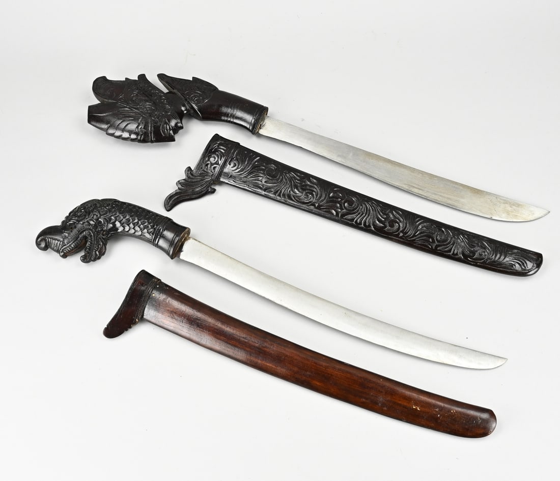 2x Indonesian blank weapon: Two Indonesian machetes. Woodcarved. Second half 20th century. Dimensions: L 58 - 64 cm. In good condition.