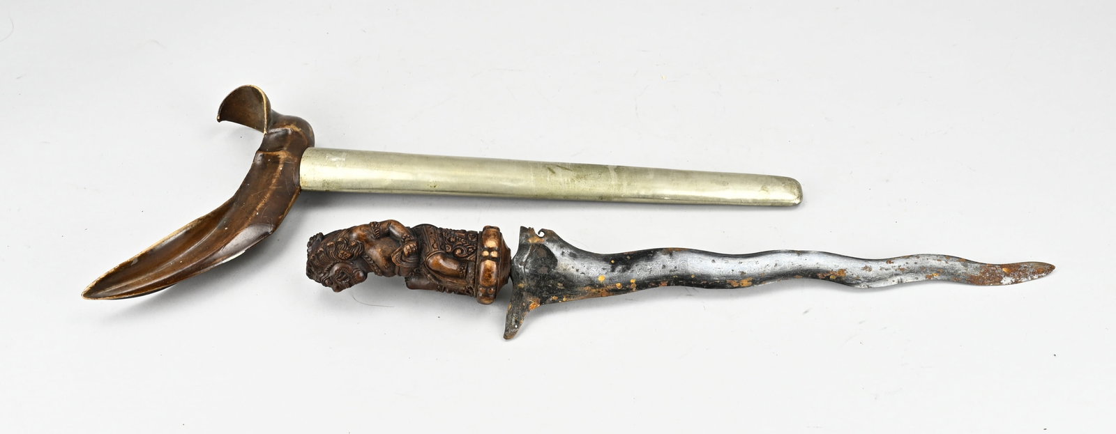 Kris (Indonesia): Beautiful old/antique Indonesian kris with hardwood carved handle, with Indonesian mythical figure. Damask blade with silver inlay. 20th century. Dimensions: L 46.5 cm. In good condition.