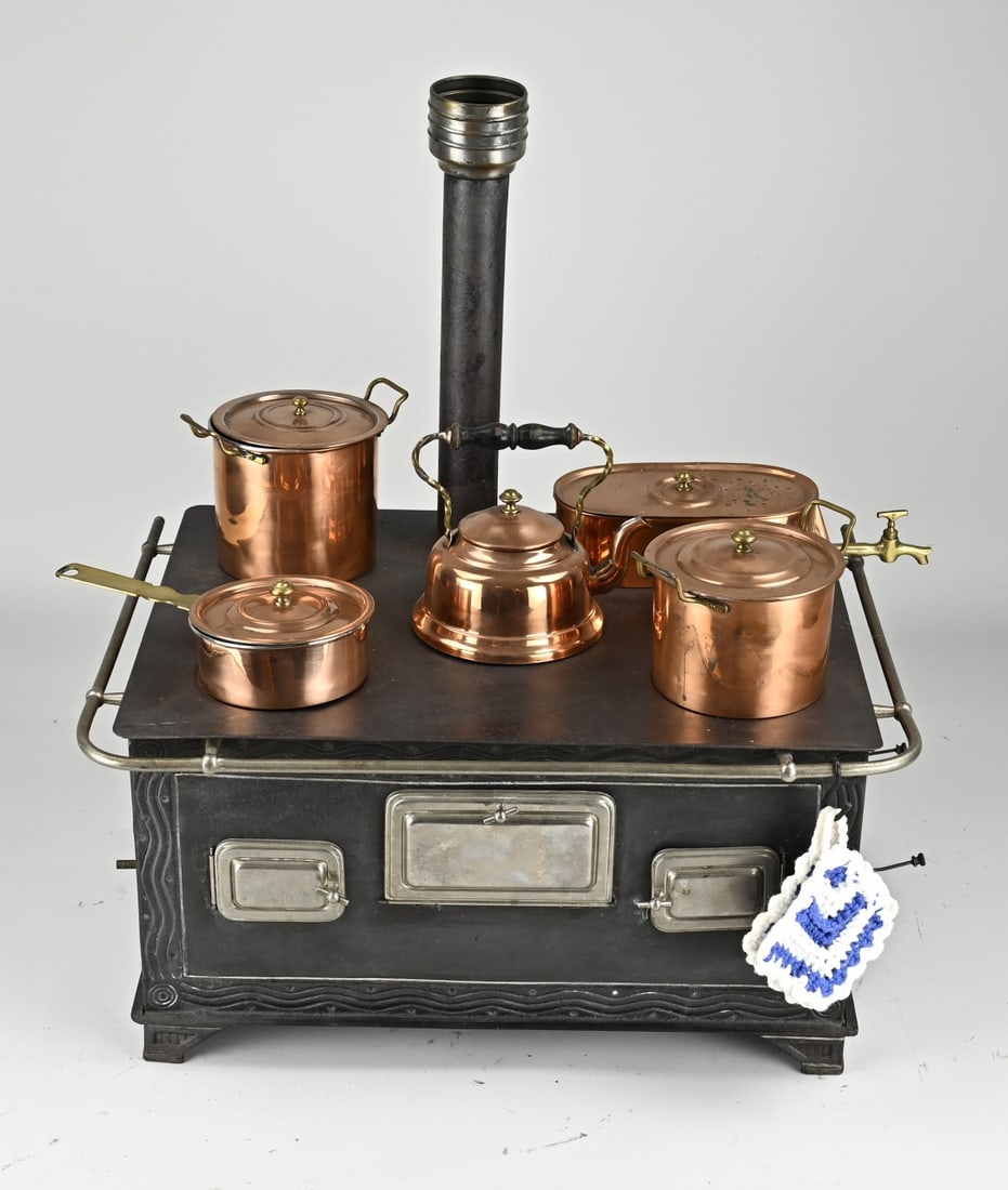 Children's stove + copper pans: Antique German children's stove made of tin, with original copper pans. With chimney. Circa 1910. Possibly Märklin or Bing. Dimensions: 50 x 45 x 34 cm. In good condition.