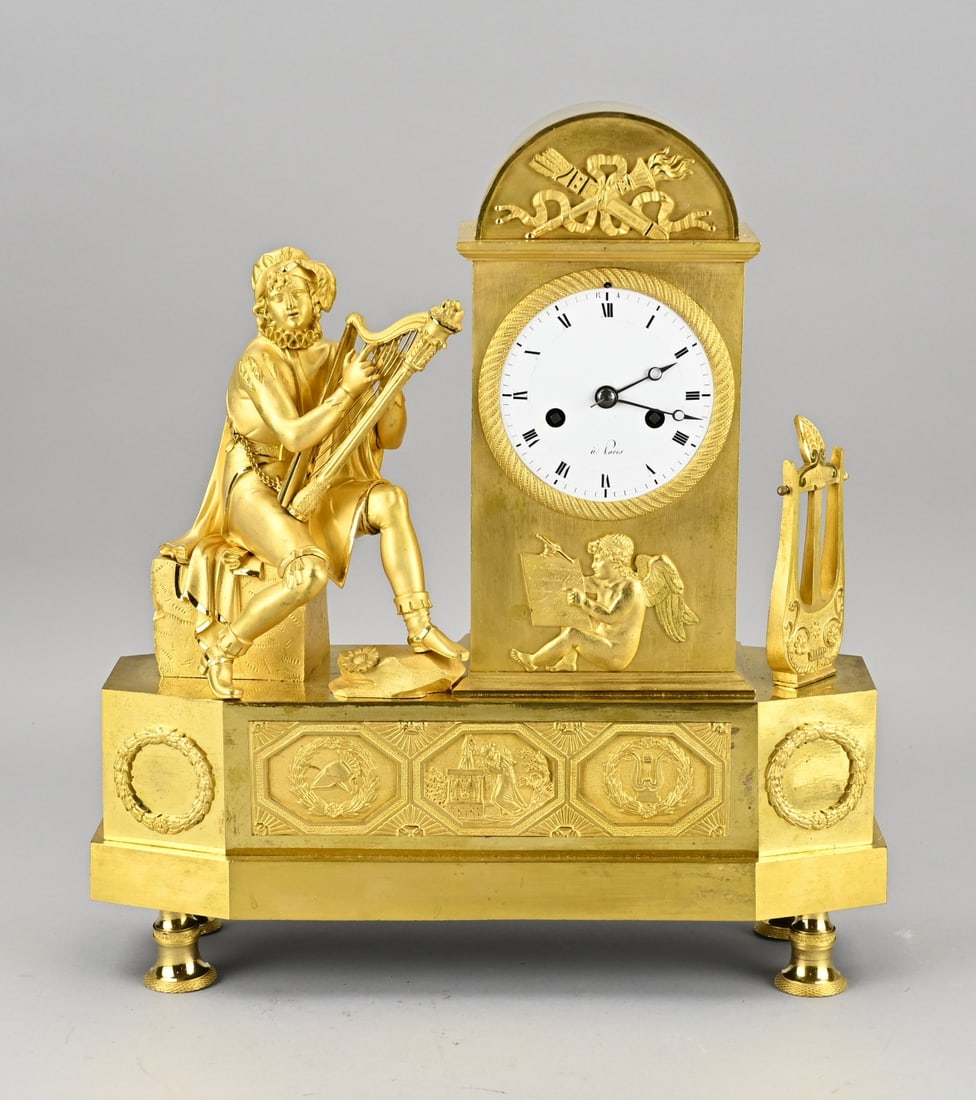 French Empire clock: Beautiful fire-gilded French Empire pendulum in bronze. Man with lyre. Beautiful gilding. Eight-day movement, half-hour strike and string pendulum. Dimensions: 36 x 33 x 12 cm. In good condition.