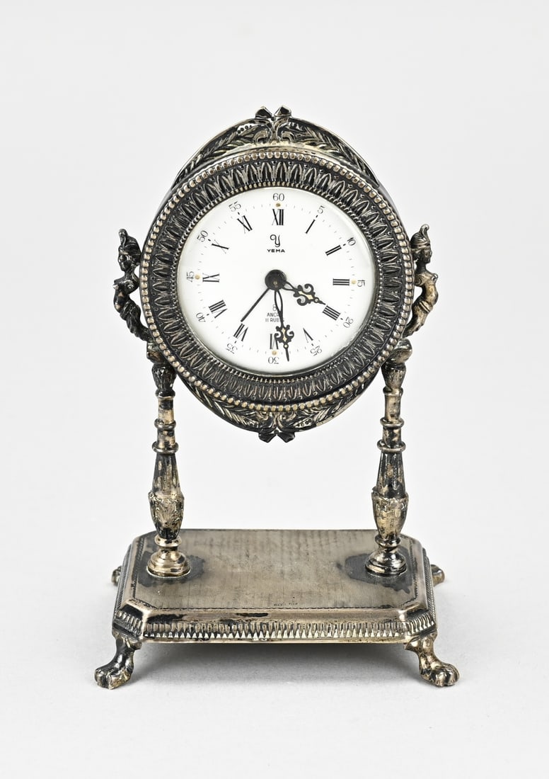 Miniature alarm clock (brass): Miniature alarm clock, silver plated, round model with knerrenrand and pearl decoration. Placed on a rectangular base with 4 claw feet and a worked edge and 2 stands with female figures. Marked Yema.