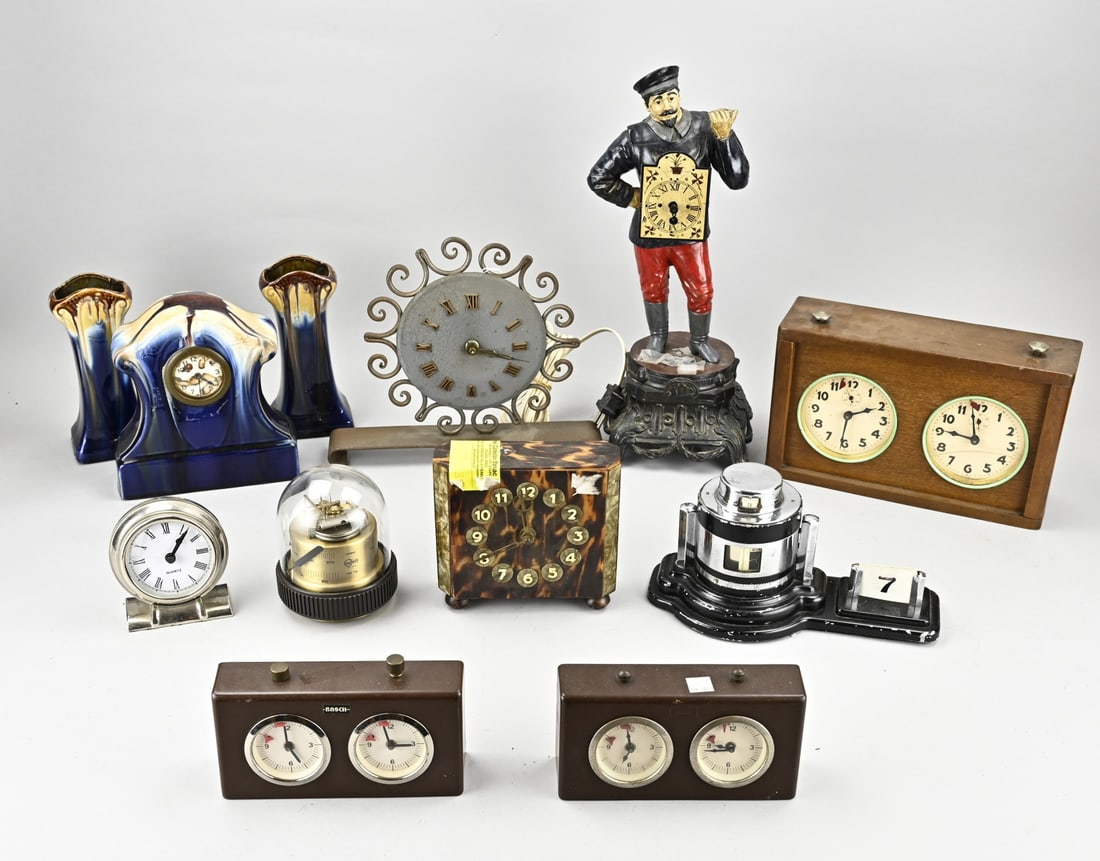 Lot of old/antique clocks: Lot with various old/antique clocks. 20th century. Among other things; ceramic, metal, wood. Art Deco, Black Forest, chess clock etc. All together in a box. Dimensions: 20 - 40 cm. In reasonable/good