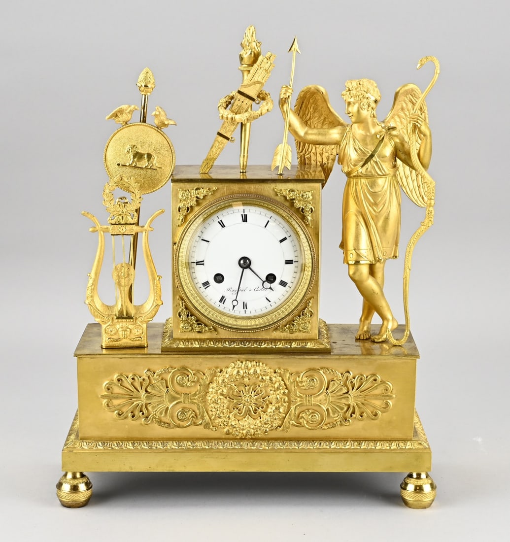 French Empire clock, 1820: Antique fire-gilded bronze Empire mantel clock with Roman figures, Amor, lyre and banner. Circa 1820. Eight-day movement, half-hourly striking, string pendulum. Size: 37 cm. In good condition.