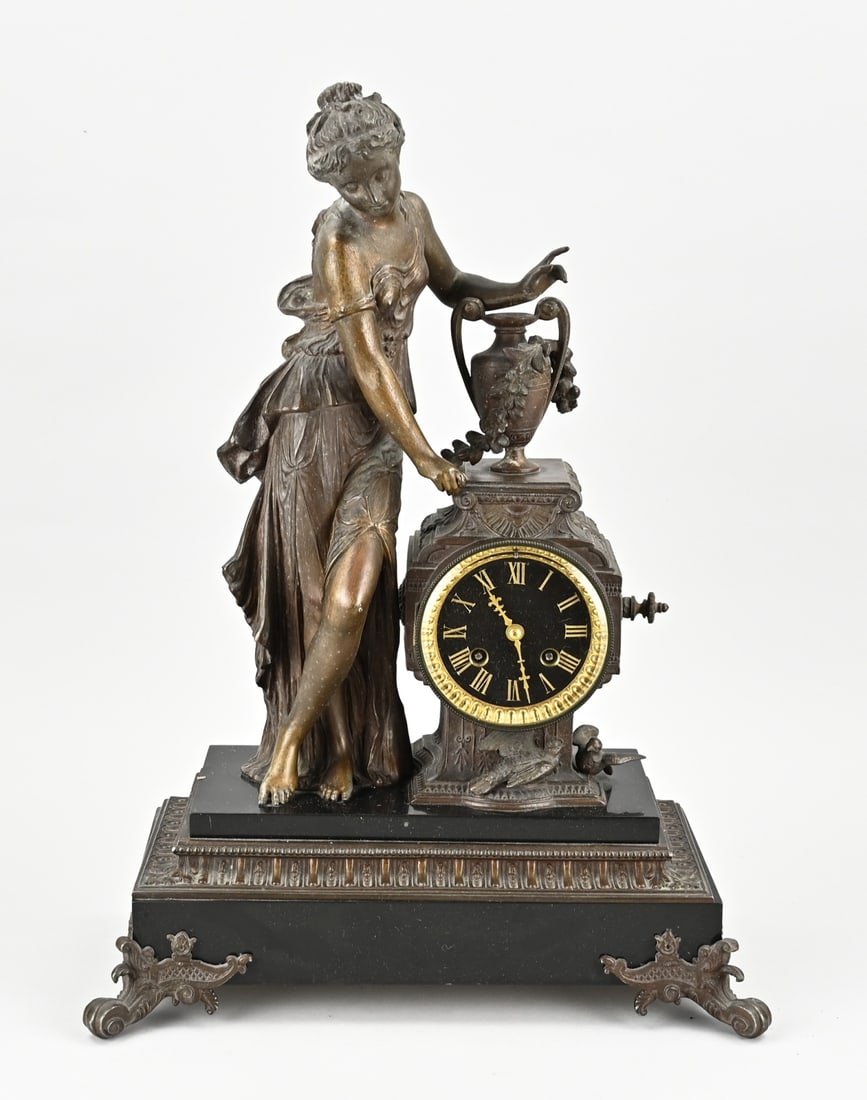 French pendulum clock, 1880: Antique French composition metal mantel clock. Greek woman with vase. Marble base. Circa 1880. Eight-day movement, half-hourly striking, spring pendulum. Size: 48 cm. In good condition.