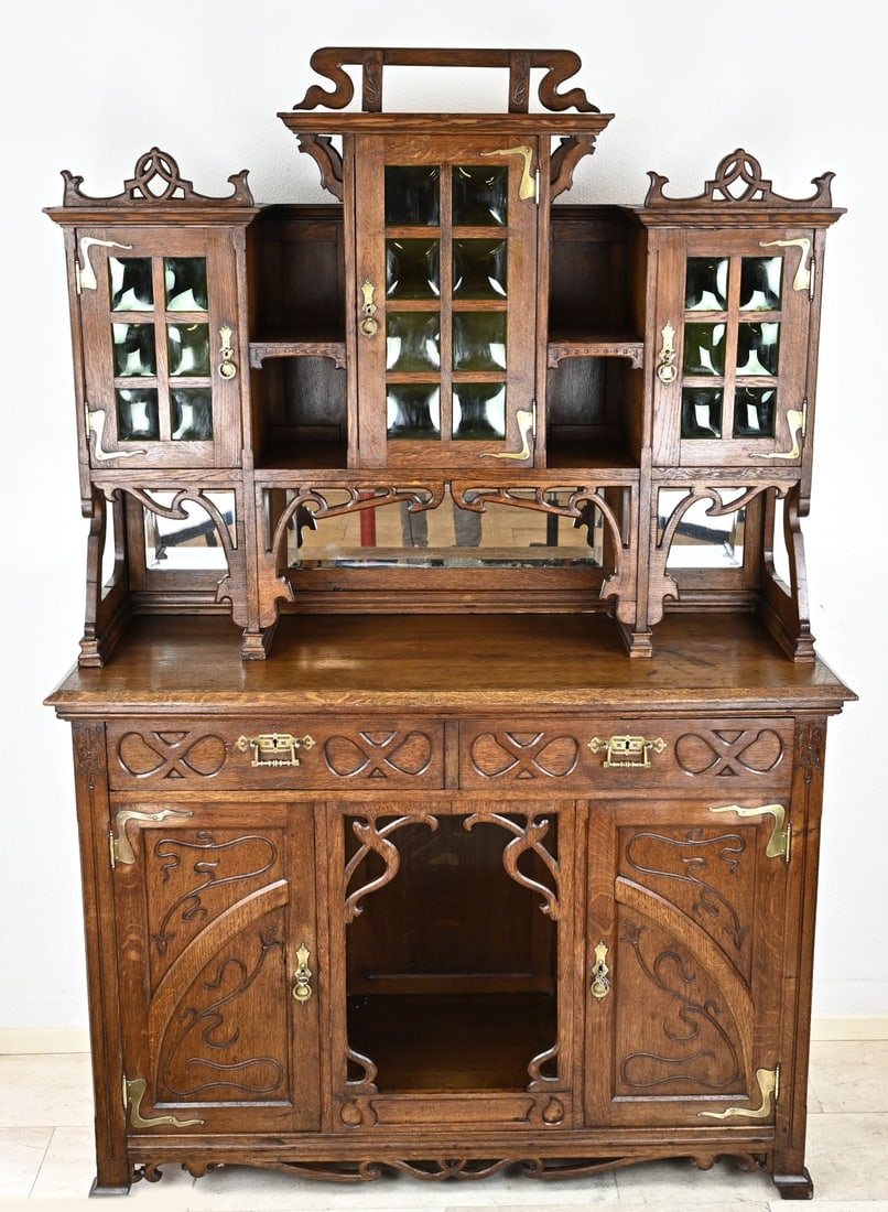 Art Nouveau sideboard: Beautiful Art Nouveau showpiece sideboard. Circa 1910 - 1920. The cabinet has typical Art Nouveau carvings, crowns and curls everywhere. Fitted with beautiful brass Art Nouveau fittings. The top has