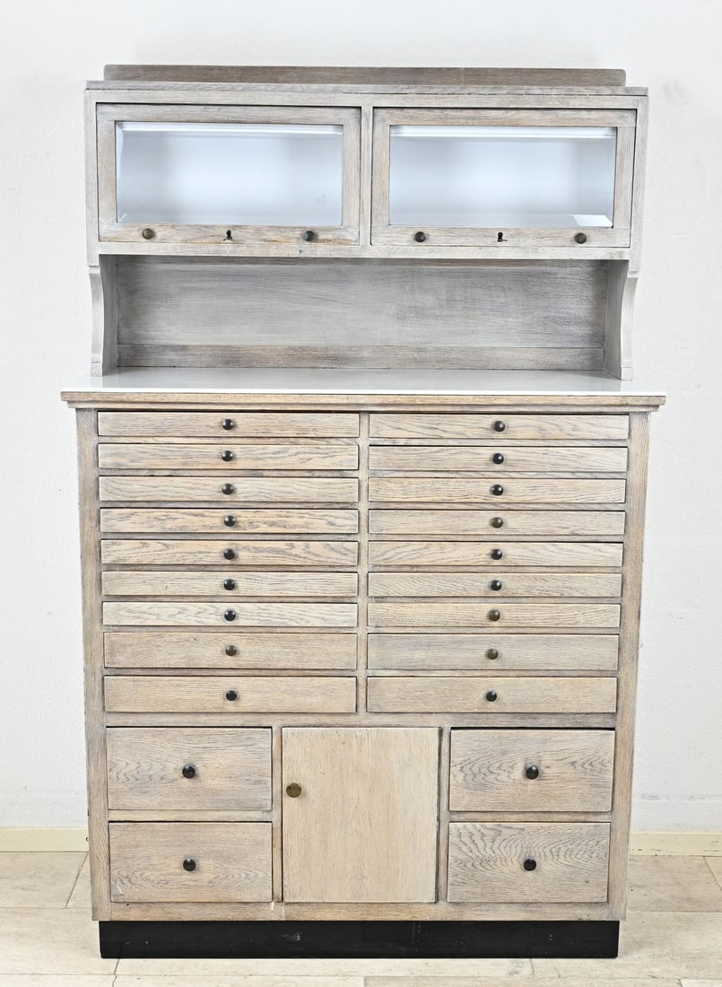 Art Deco dentist cabinet: Two-piece Dutch dentist cabinet, made of oak with marble top. Circa 1920. Art Deco. Cabinet has 3 doors and 22 drawers. White wash patinated. Dimensions: 172 x 110 x 46 cm. In good condition.