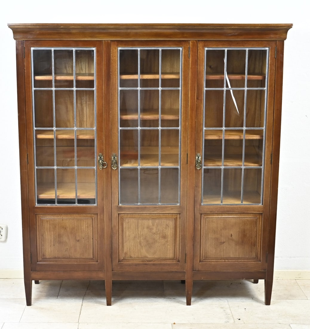 Mahogany bookcase: Solid mahogany 3-door book/display cabinet with original stained glass. Signed: Pander Den Haag. Dimensions: 151 x 142 x 38 cm. In good condition.