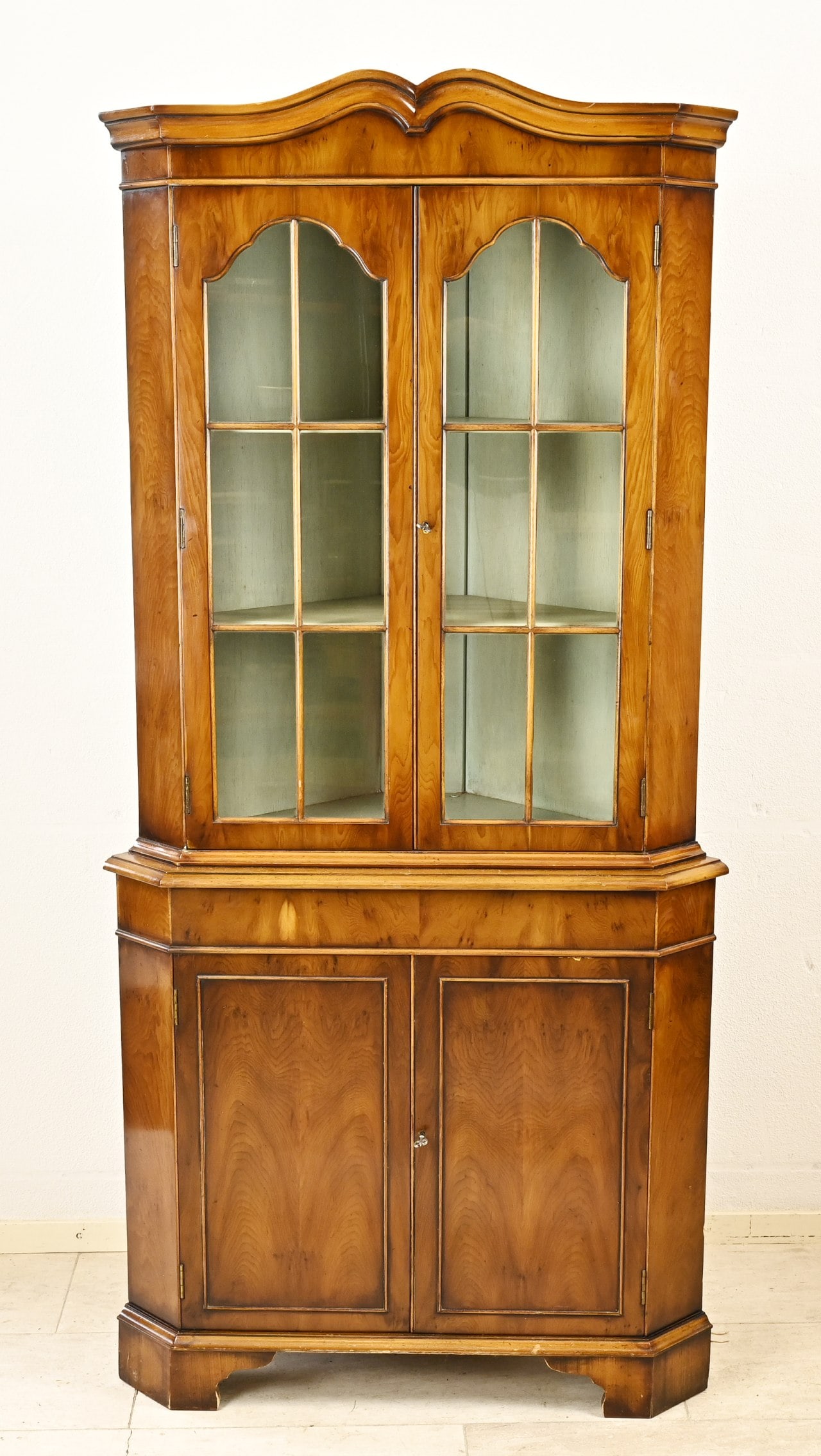 English corner cupboard: English corner cabinet-display case of fruitwood. Four doors. 20th century. Dimensions: 186 x 85 x 45 cm. In good condition.