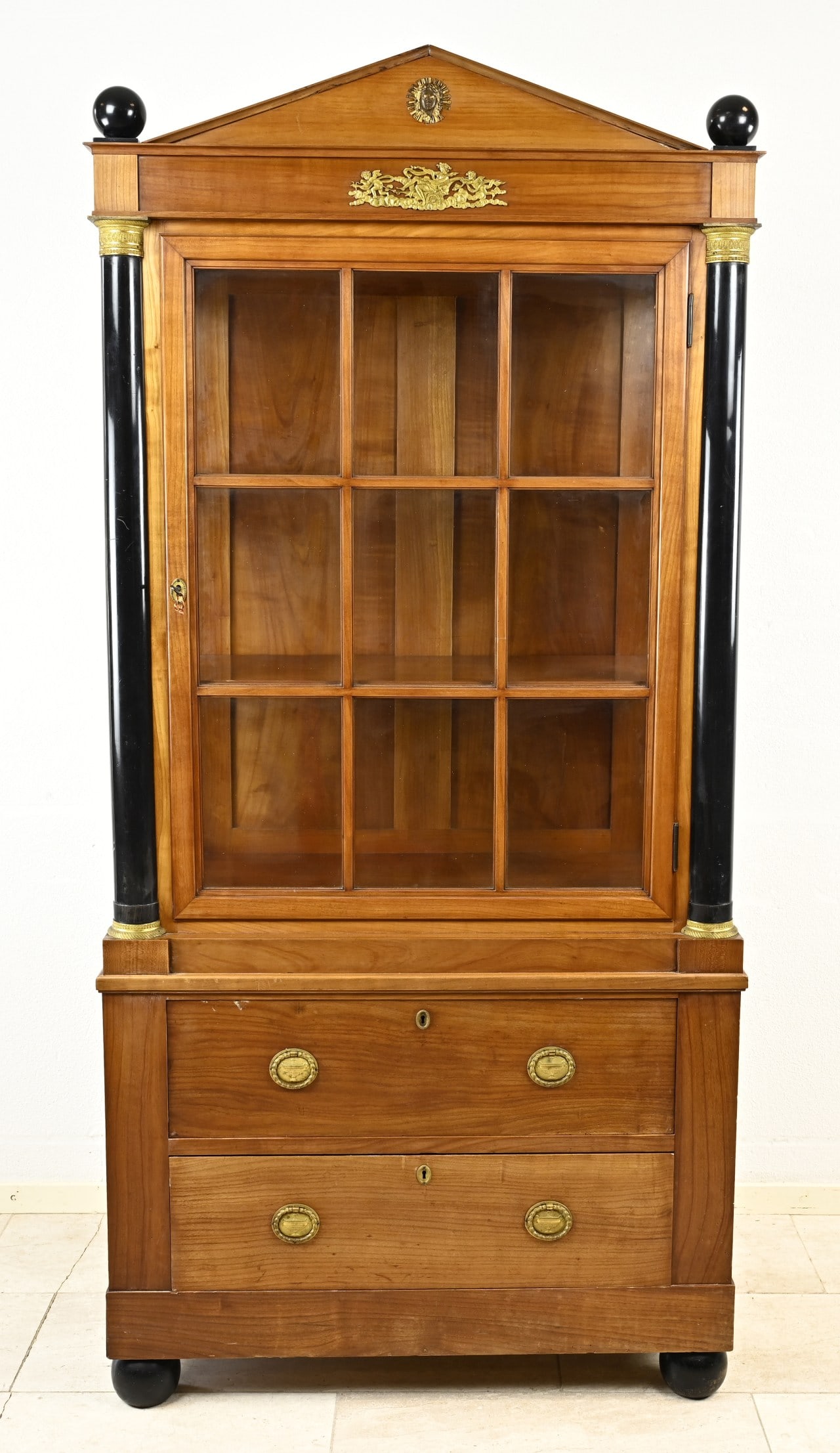 Cherry display cabinet: Cherry wood display cabinet in empire style, with black bronze columns and gilded bronze decoration. Circa 1900. Dimensions: 189 x 88 x 45 cm. In good condition.