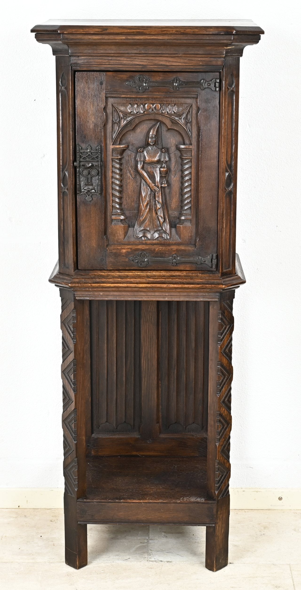 Gothic style credenza: Solid oak credential cabinet in Gothic style, with an image of a maiden in the door. 19th century. Dimensions: 130 x 50 x 35 cm. In good condition.
