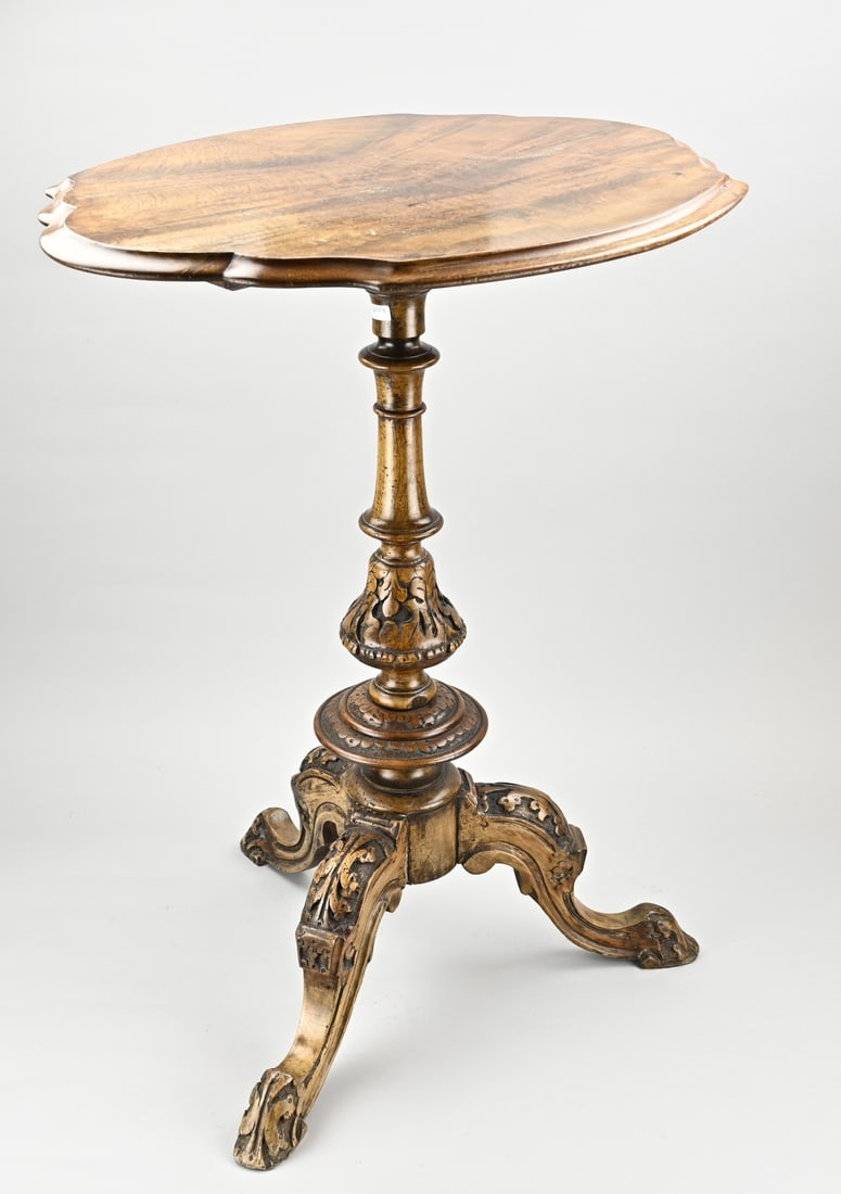 Antique side table: Antique walnut side table with contoured top. Table has a carved floral 3-span leg. Dimensions: 73 x 59 x 46 cm. In good condition.