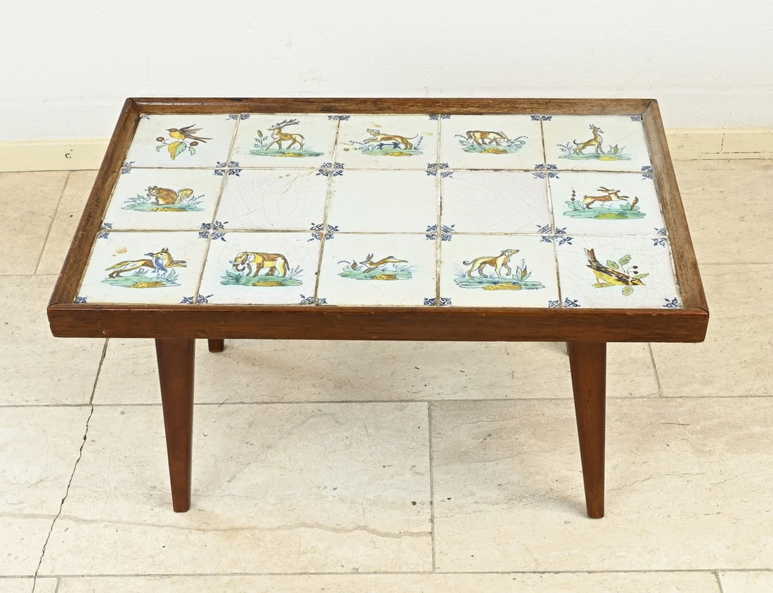 Table inlaid with tiles: Low side table with fifteen polychrome 17th century tiles. Various decor. Two tiles hairline cracks. Dimensions: 40 x 71 x 45 cm. In reasonable/good condition.