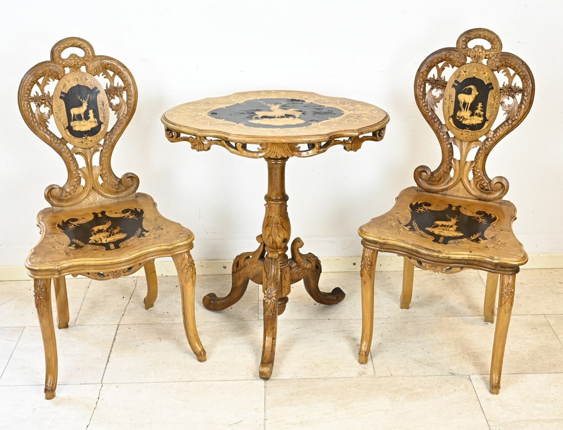 3-Piece Black Forest Set: Rare 3-piece hunting set, consisting of two chairs and a table. With beautiful carving and inlaid with chamois/deer. 19th century. Southern Germany/Austria. Table size: 74 x 66 x 46 cm. Chair size:
