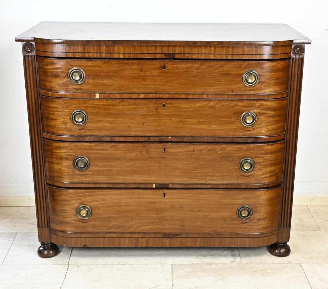 English/Vicotrian chest of drawers: English Victorian mahogany chest of drawers, with brake front. Chest of drawers has four drawers with ring fittings. Circa 1860. A few pieces of veneer are missing. Dimensions: 104 x 122 x 56 cm. In