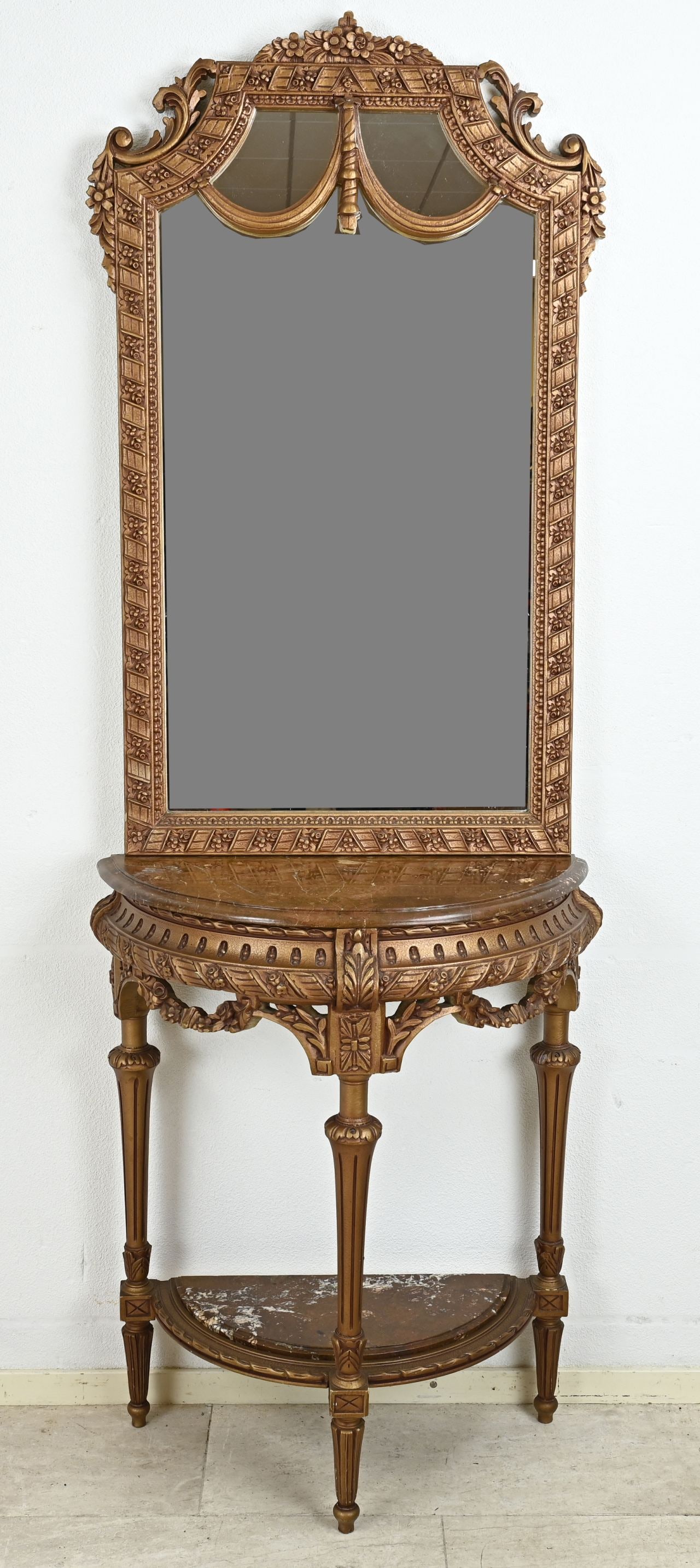 Wall table with mirror: Gold-colored carved wood wall table with marble tops. Louis Seize style. Second half of the 20th century. Dimensions: 203 x 77 x 40 cm. In good condition.